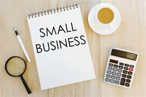 Small business concept with notebook, coffee cup, magnifying glass, and calculator on desk